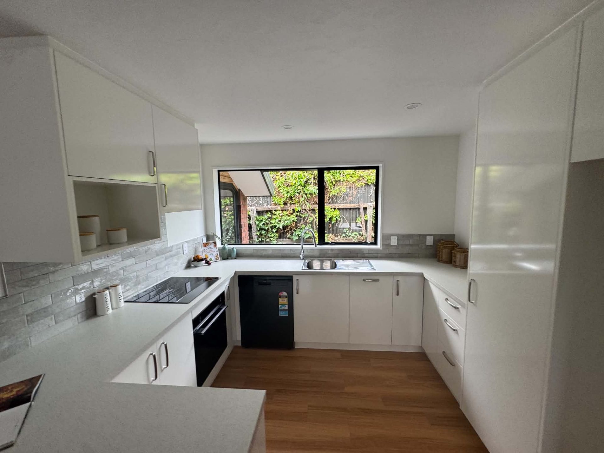 Modern white kitchen interior with freshly painted cabinetry and walls