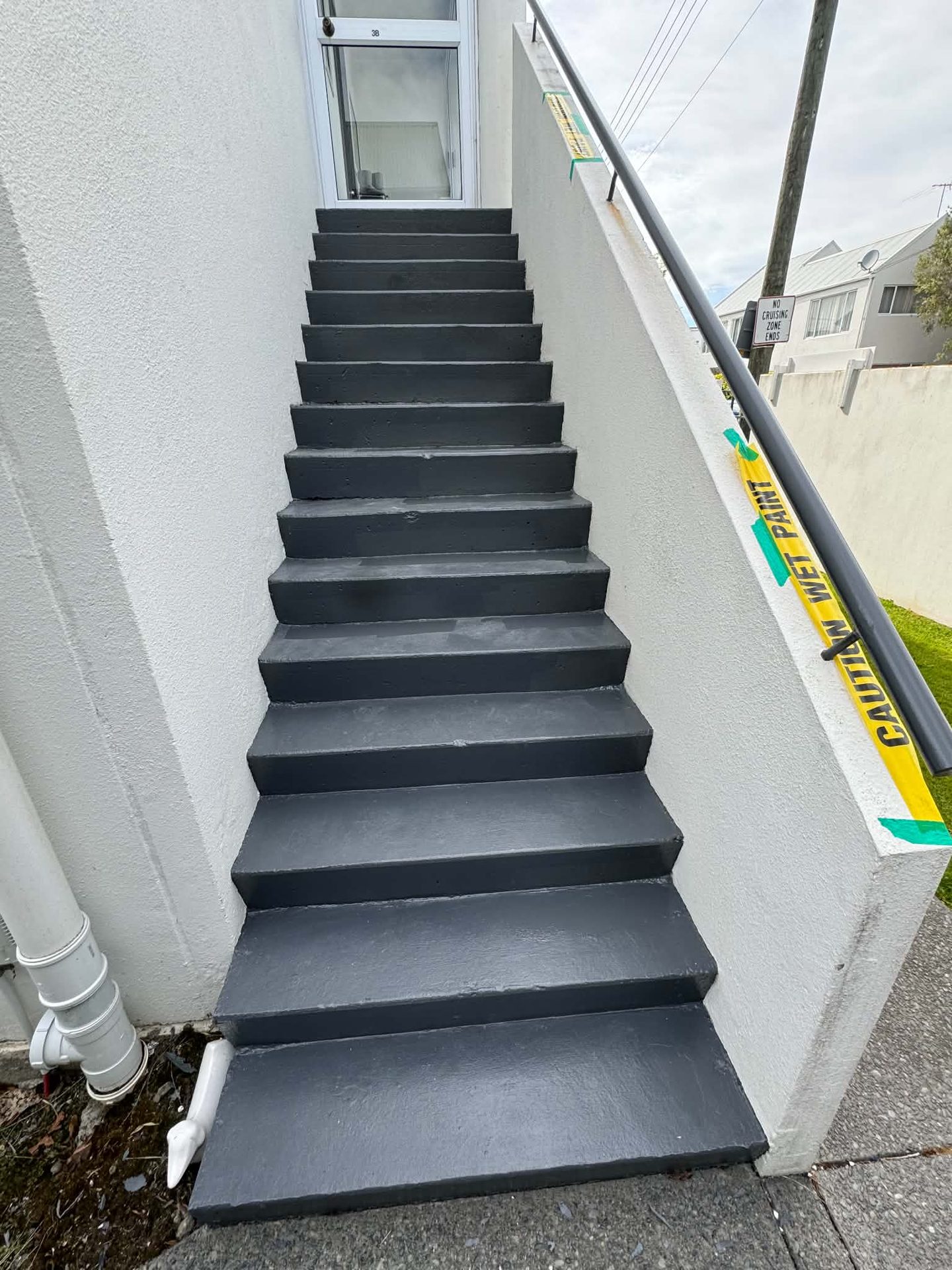 Exterior concrete staircase finished in a dark grey protective coating